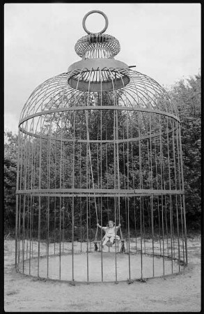 Mädchen schaukelnd in einem Käfig im Filmpark Babelsberg
