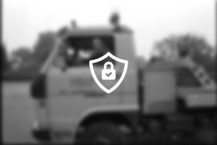 Wirtschaft: Kraftfahrzeug-Meisterbetrieb [Name maskiert] + [Name maskiert] Hauptstraße: Parkplatz: Mitinhaber Kfz-Meister [Name maskiert] an Steuer von Abschleppwagen [Teilansicht], auf Tür Firmenname