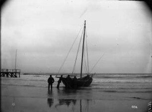 Ostseeküste. Fischerboot am Strand, daneben Landungssteg