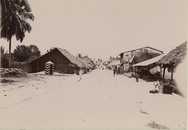 Rue avec des maisons et des magasins, ainsi que des postes militaires