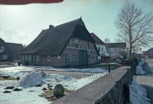 Reinbeker Straße 4a: giebelständige Fachwerkkate mit Reetdach: Giebelseite Wirtschaftstrakt mit Scheunentor: Traufseite, links Wohntrakt, Eingangstür