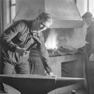 Lehrlinge von Borgward beim Schmieden am Amboss mit Hammer und Zange