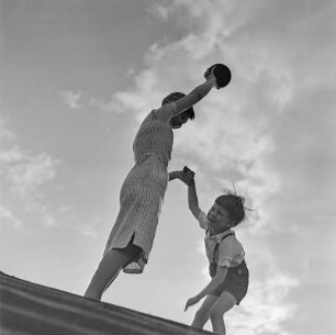 Elisabeth Gremmler und ihr Kind spielen Ball auf einer Treppe