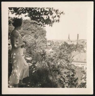 Portrait einer jungen Frau auf eine Stadt blickend