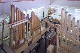 Viermanualige Orgel für die Hauptsynagoge in Budapest op. 1121 : Montagesaal mit Galerie. Aufpassen der Holzpfeifen auf der Windlade während der Werkstattmontage der Orgel für die Hauptsynagoge in Budapest (op. 1121)