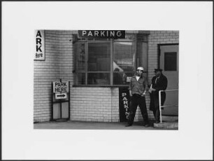 Zwei Männer vor dem Kassenhaus eines Parkhauses oder Parkplatzes, New York