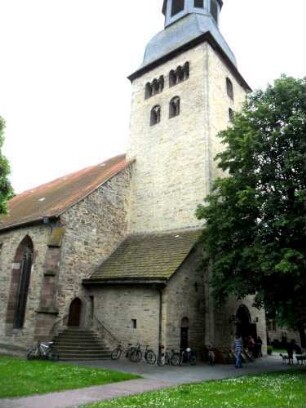 Ansicht von Nordwesten mit Kirchturm (Bi- und Triforien) sowie Langhausansatz über Kirchhof