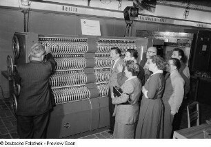 Besucher der Leipziger Herbstmesse 1954 betrachten ein Exponat der Vereinigung Volkseigener Betriebe des Elektromaschinenbaus (VEM)