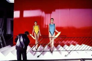 Models auf einer Treppe mit Geländer vor rotem Hintergrund, Werbeaufnahme für Müssig AG