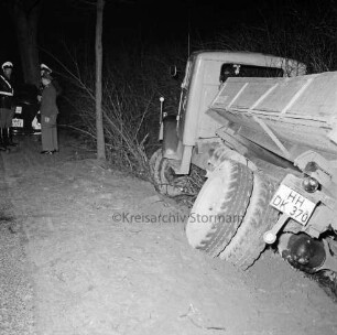 B 75: zwischen Blumendorf und Neritz: Verkehrsunfall: Lkw fährt in Straßengraben: Unfall-Kieslaster schräg an Grabenböschung: hinten links an Straßenrand Polizisten, Polizeiwagen: Baum, Büsche: im Dunkeln, 5. März 1961