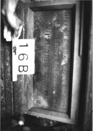 Grabstein 16 (Index: 99804463) Material: Sandstein Zustand: stark verwittert und abgeblättert Maße HxBxT: 176x63x32 cm Beschreibung: ädikulaartige Stele mit Halbsäulen, getreppter Sockel, Abschluß mit Zinnenaufsatz, Schriftfeld mit Maßwerk Symbolik: stilisierte Blätter, Maßwerk Besonderheit: kulturhistorisch wertvoll / künstl.-formale Gründe (Ornamentik, Form): Grabstein 16B (Detailaufnahme 2)