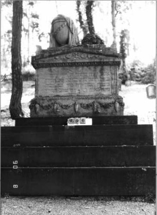 Grabstein 496 (Index: 99791127) Zustand: Rückseite stark verwittert Maße HxBxT: 310x140x77 cm Symbolik: Urne auf Trauerflor, 10 Urnen Besonderheit: kulturhistorisch wertvoll / hist.-wiss. und künstl.-formale Gründe (Gemeindestellung, Inschrift): Grabstein 496
