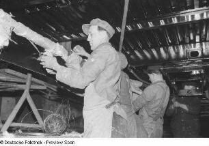 Arbeiter beim Abdichten von Rohren an einem Waggon