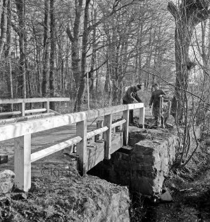 Grönwohldhof: Dorfstraße: Ausbau der Kreisstraße Richtung Dwerkaten: links Brücke über Schönau mit Holzgeländer: hinten Bäume