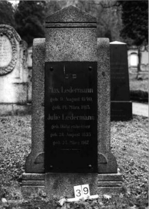 Grabstein 39 (Index: 100092768) Material: Stele:Granit/Platte: Metall Maße HxBxT: 153x77x28 cm Beschreibung: Stele mit Giebel-Abschluß, aufgesetzte Schriftplatte: Grabstein 39