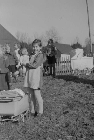 Kinder beim Spielen : Mädchen mit Puppenwagen und Spielzeugpuppen