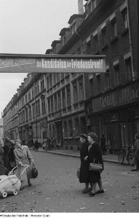 Belebter Straßenzug mit Wahlwerbung für die Volkskammerwahl am 17.10.1954