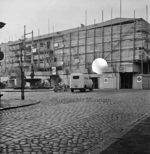 Kreissparkasse Stormarn: Markt: Hauptstelle: Gebäudetrakt am Markt während Umbau: mit Gerüsten, Leitern, Bauzaun: davor Markt mit Kopfsteinpflaster: Gänselieselbrunnen: Kleintransporter, Motorräder, Personen: junge Bäume: vorne Hagenstraße