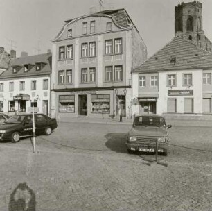 Wohnhäuser mit Läden : Beeskow (Landkreis Oder-Spree), Markt 12/10. Wohnhäuser mit Läden. Straßenansicht, im Hintergrund Pfarrkirche St. Marien