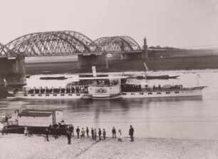 Riesa. Personen-Seitenraddampfer "Kaiser Wilhelm II" in der Höhe der Anlegestelle auf Fahrt stromauf. Blick vom Elbkai nach Norden zur Eisenbahn und Straßenbrücke