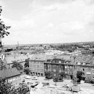 Erweiterungsbau [später Gebäude C] mit Kreistagssitzungssaal: IV. Bauabschnitt: Baubeginn an der Reimer-Hansen-Straße: links Erweiterungsbau II. Bauabschnitt: vorn Baugrube: dahinter parkende Pkws vor Wohnblocks: rechts Baukran: Blick vom "Hochhaus" [später Gebäude B] über Bad Oldesloe Richtung Lübeck