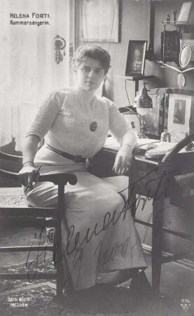 Porträt Helena Forti : Porträt Helena Forti (1884-1942; Sopranistin, ab 1914 Kammersängerin). Ganzfigur, sitzend vor Schreibsekretär. Fotografie (Weltpostkarte mit Autogramm, datiert 9. Nov. 15) von E. Müller (Hahn Nachf.). Dresden, 1914/1915