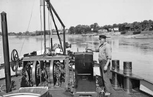 Elbschiffer, Bootsmann beim Streichen des Motorkastens der Ankerwinde auf einem Motorschiff
