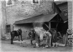 Dorfschmiede : Frohburg, Dorfschmiede. Hufbeschlag, Aufsetzen des glühenden Hufeisens
