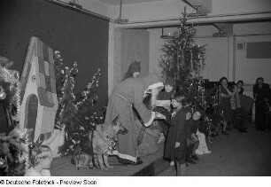 Blick auf die Bühne mit Weihnachtsmann, ein Geschenk überreichend