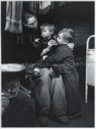 Mutter mit ihren beiden Kindern in einer Notunterkunft