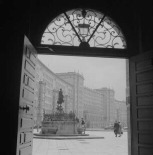 Blick durch ein Eingangstor auf die Ringbauten und den Mägdebrunnen am Roßplatz