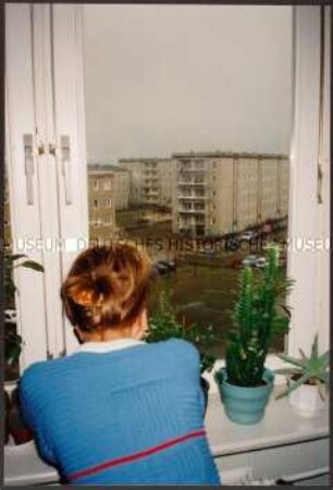 Mädchen schaut zum Fenster raus (Altersgruppe 18-21)
