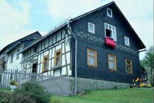 Wohnhaus, Giebelseite mit Stanniolmalerei, Federbett zum Lüften im Fenster