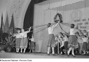 Mädchen tanzen um einen Maibaum beim Bezirksausscheid der Volkskunstgruppen 1954
