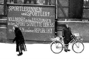 Sport-Staffette DDR35 : Großsteinberg. Straßenszene mit zwei Frauen vor einem Plakat