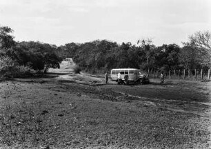 Kleintransporter : Der Kleintransporter hält auf einer Straße. Daneben ein Grenzzaun.