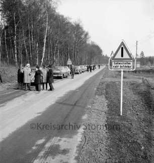 Vinzier: Gemeindestraße zwischen Vinzier und Neverstaven: Einweihung: Autokorso und Besichtigung der Straße im Beisein von Landrat Wennemar Haarmann, Amtsvorsteher Hans Hagen, Bürgermeister Fritz Krasmann und Ehrengästen: links dahinter Neverstavener Forst: vorn rechts Straßenschild