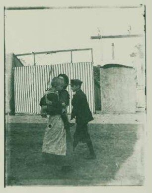 Mädchen mit Kleinkind und Junge auf dem Rummelplatz
