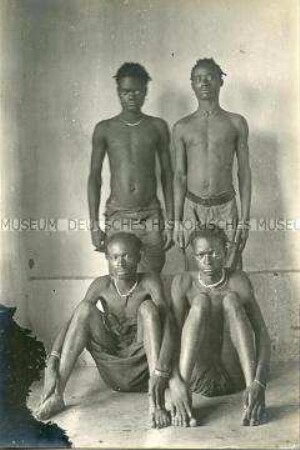 Gruppenbild von vier jungen Männern der Bidjuk und der Biakum vor neutralem Hintergrund