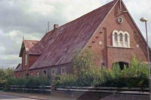 Rohlfshagen: An der Sylsbek 2: Bauernhaus: Traufseite: links Wohntrakt mit Eingangstür und Zwerchgiebel, rechts Wirtschaftstrakt: Giebelseite Wirtschaftstrakt mit Scheunentor, Bogenfenstern
