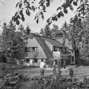 Haus mit Reetdach inmitten eines Gartens