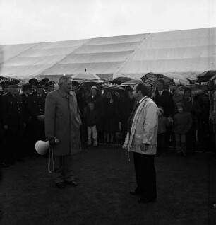 Dorferneuerung: Volksfest: Sportplatz: Einweihung: vorn links Bürgermeister Heinz Tebelmann mit Megafon: rechts Sportvereinsvorsitzender Schacht: dahinter Feuerwehrmannschaft und Zuschauer mit Regenschirmen: hinten Festzelt