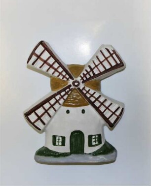Windmühle mit braun-weißen Flügeln und grünen Fenstern