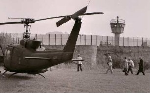 Ein US-Hubschrauber am 3. Oktober 1988 direkt an der innerdeutschen Grenze bei Philippsthal in Hessen am Werraufer, gegenüber die Stadt Vacha, DDR. Mit Grenzturm + Stahlgitterzaun, davor deutsche Journalisten