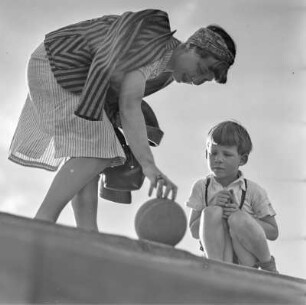 Elisabeth Gremmler und ihr Kind spielen Ball auf einer Treppe
