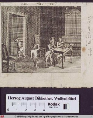 Vier Jungen in einem Zimmer, einer schreibt am Tisch, die anderen spielen.