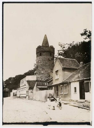 Zerbst. Straße mit spielenden Kindern, im Hintergrund Turm der Stadtbefestigung