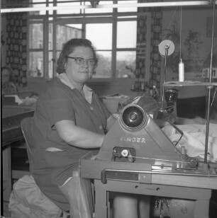 Roßwein, Bahndammstraße. VEB Maßmieder- und Wäschefabrik (vormals Karl Spranger Maßkorsettfabrik). Vorgänge in der Produktion. Näherei. Näherin an einer Singer-Nähmaschine