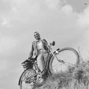 Elisabeth Gremmler mit Sonnenbrille steht hinter ihrem Fahrrad
