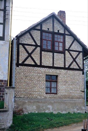 Giebel eines schmalen Wirtschaftsgebäudes mit Schornstein